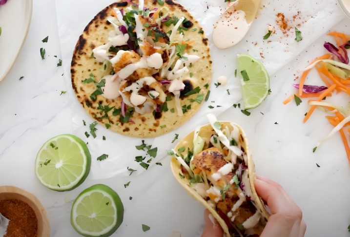 Crispy fish tacos, topped with creamy sauce and fresh slaw