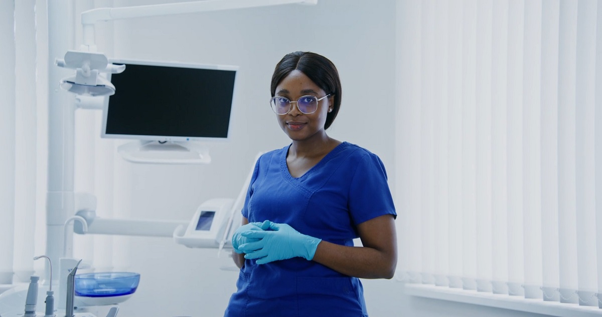 A dental professional standing in a clinic with confidence, highlighting an active and professional lifestyle