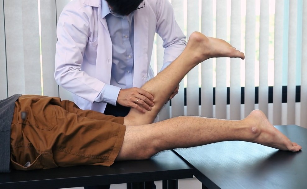 Expert hands assess the leg's range of motion