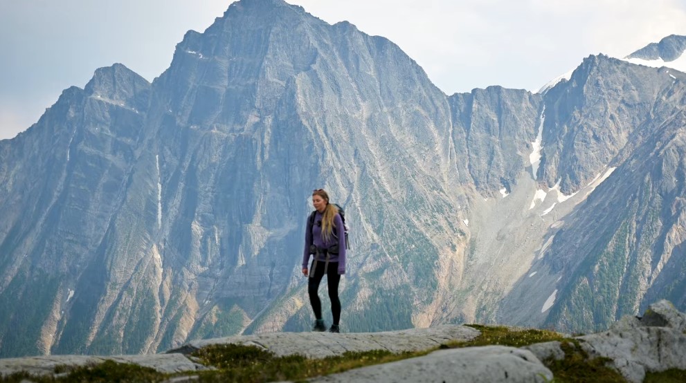 A hiker, silhouetted against a majestic mountain range