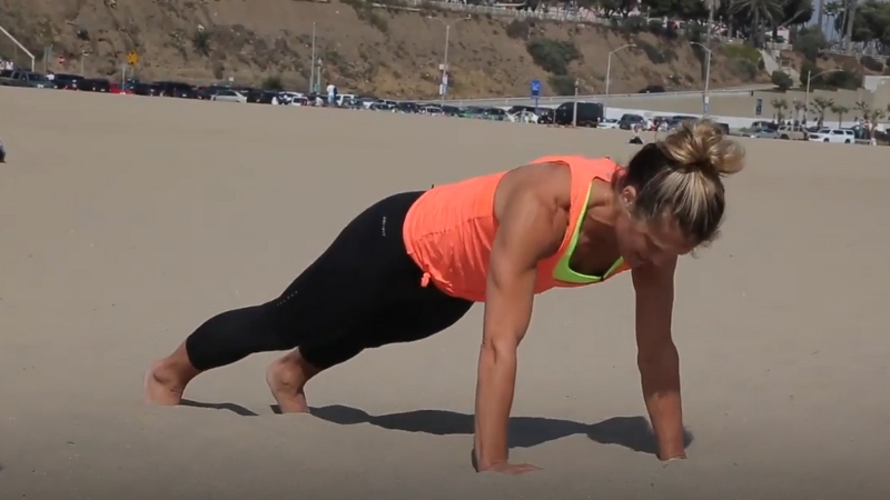 A Person Doing Push-Ups on The Sand