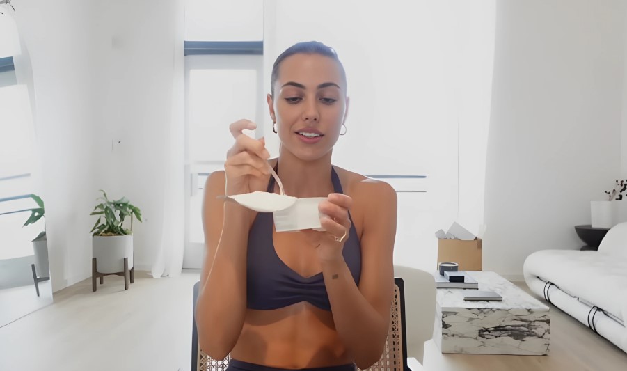 A woman eats protein yogurt in the kitchen