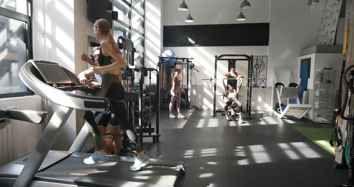 A spacious gym with several people working out.