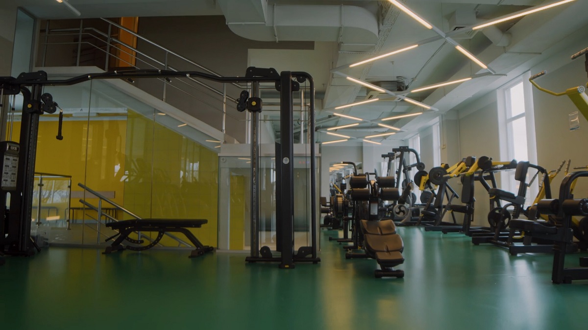 A modern and spacious gym with various exercise machines neatly arranged