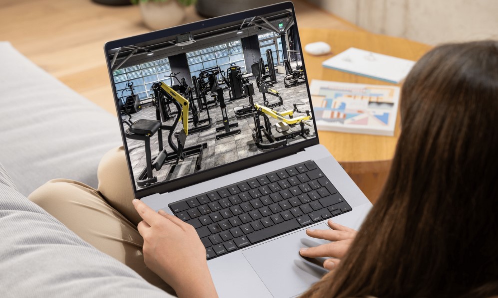 A laptop displays a comprehensive view of a modern gym's equipment layout