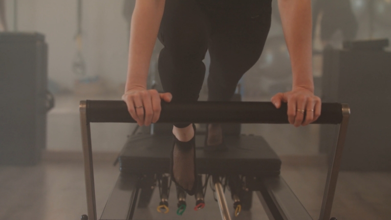 A person working out on a reformer machine after reaching their weight loss goal