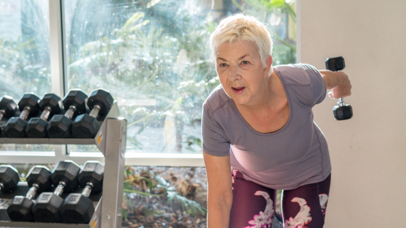 Older woman lifting a dumbbell during a strength training workout at home