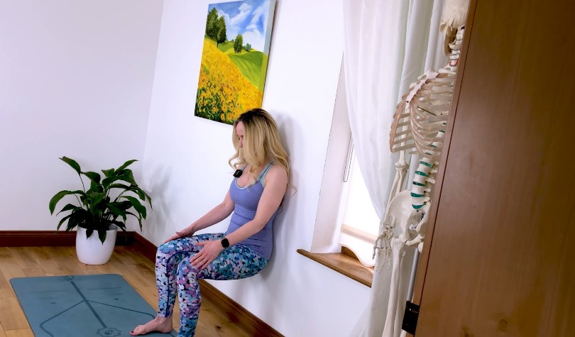 Woman doing wall squats in her room