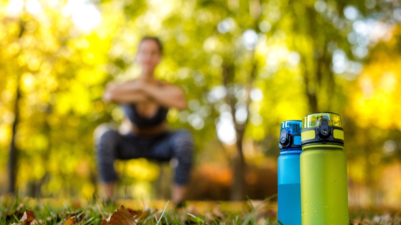 Water bottles on grass during outdoor training in a sunny park