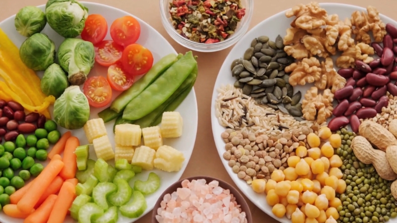 Plates filled with colorful vegetables, legumes, seeds, and nuts showcasing a variety of high-fiber foods for better digestion
