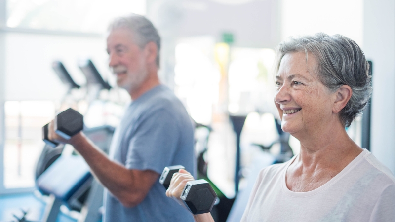 Older adults lifting dumbbells during a strength workout