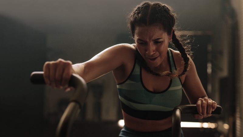 Woman struggles during intense workout, linked to Bell's Palsy risk