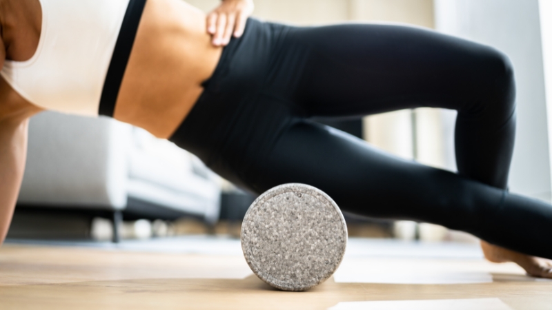 A person using a foam roller on their thigh, showing a common rolling technique