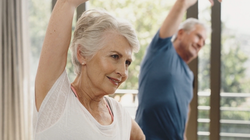 Older adults stretching together in natural light, showing how regular exercise supports skin health and overall vitality