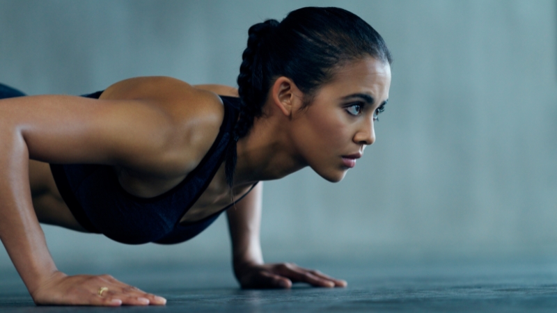 A focused woman in a push-up position, showing determination—highlighting how a prescription can affect physical performance and workout effort