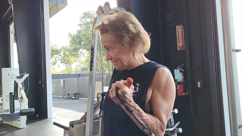 Marlene Flowers curls a resistance band during an arm workout at her gym