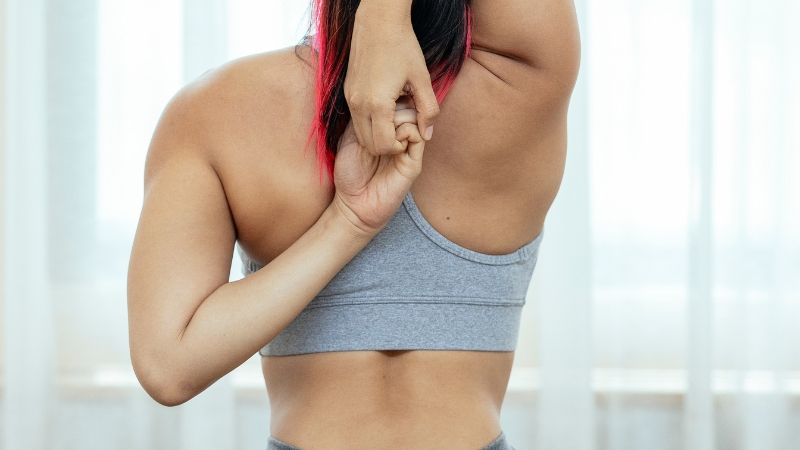 Woman stretching her shoulders and back, focusing on flexibility and posture improvement