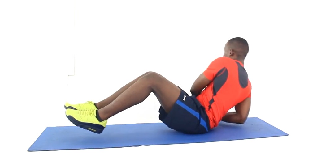 Man performing seated oblique twists on a yoga mat with no equipment