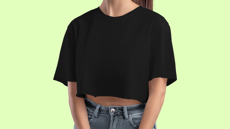 Woman wearing a loose black crop top and high-waisted jeans, with the waist mostly hidden and body shape not defined