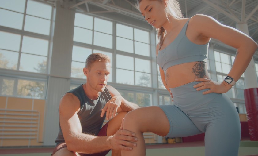 Focused attention, expert guidance. A trainer meticulously assesses a client's knee