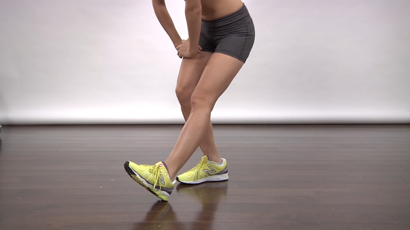 A person stands with one leg extended forward, leaning down to stretch the hamstring for sciatic pain relief