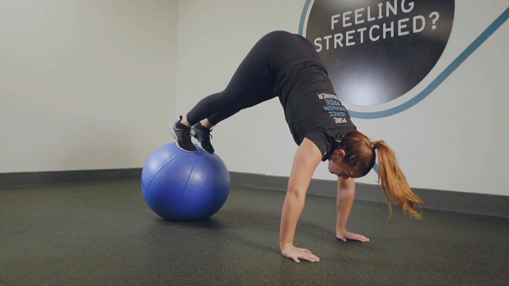 Woman performing a Swiss ball pike for core strength and stability