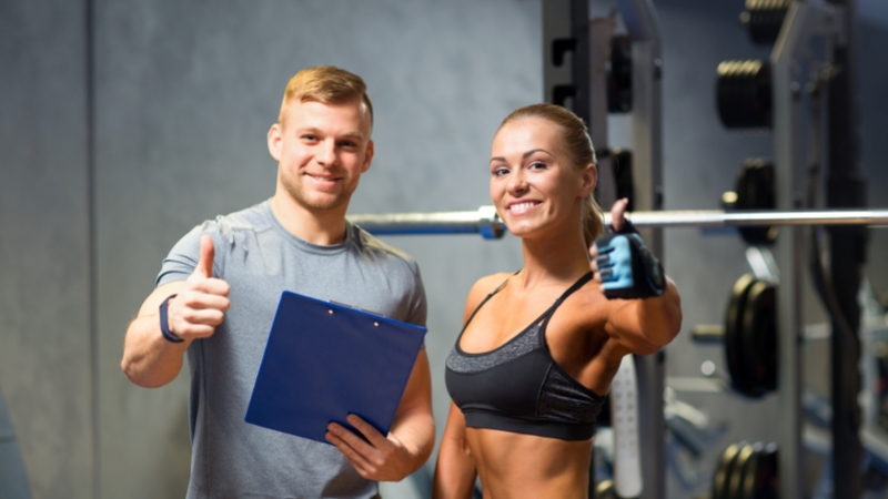 Two fitness trainers smile and give thumbs up, showing the mindset new gym owners need beyond just coaching
