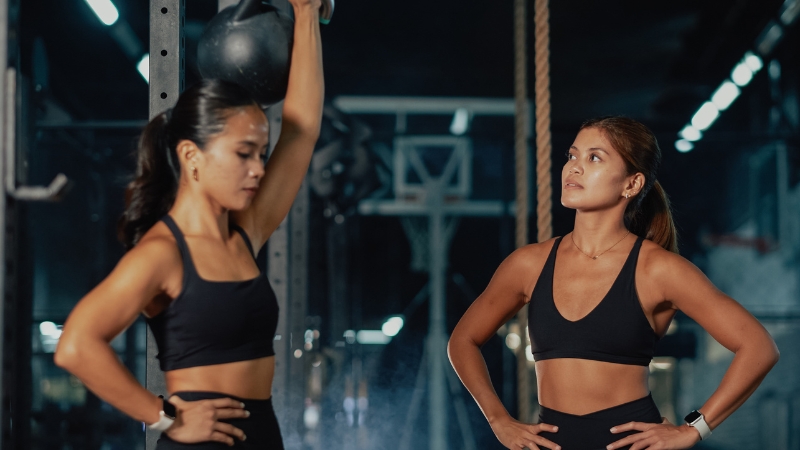 Two women train with focus in a gym, showing how ongoing learning shapes a strong fitness coaching career