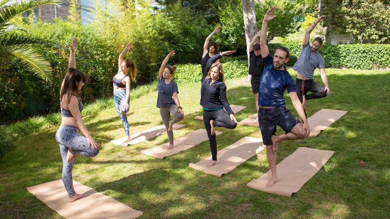 Group practicing yoga outdoors on mats, showing best practices and tips for outdoor training