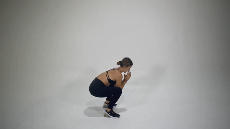 A woman performing frog squats to strengthen her legs and improve flexibility