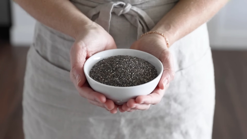 A woman holds a bowl of chia seeds as a simple step for inflammation reduction