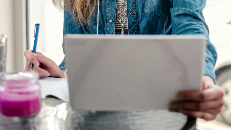 Person review pricing notes on a laptop while planning an online fitness course