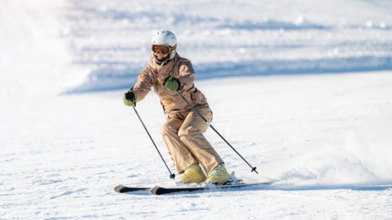 A skier moves down a snowy slope showing the core idea of skiing for fitness