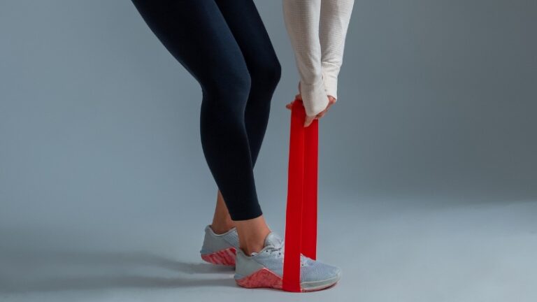 Person perform resistance band leg exercise that represent effective leg day alternatives outside the gym