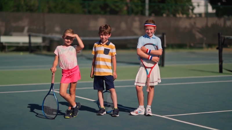 Children on a tennis court with rackets show benefits of multi sport practice