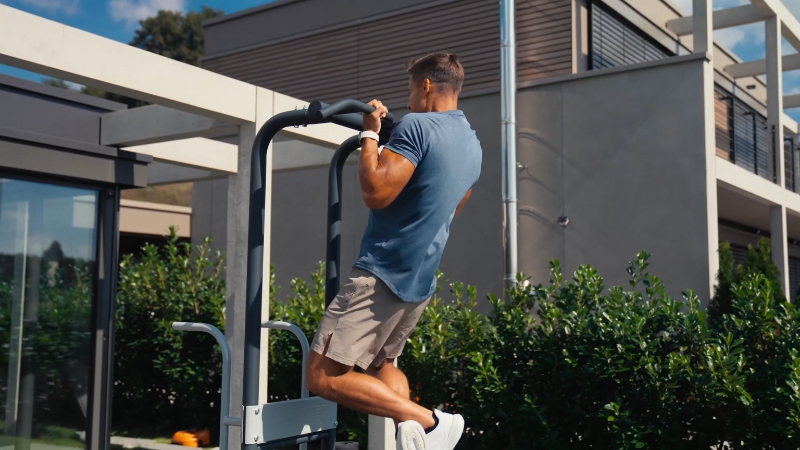 Man perform pull-ups on a Moduseries outdoor fitness unit with neutral grip handles
