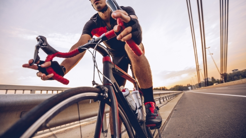 Road cyclist rides at speed on a bridge during a training session