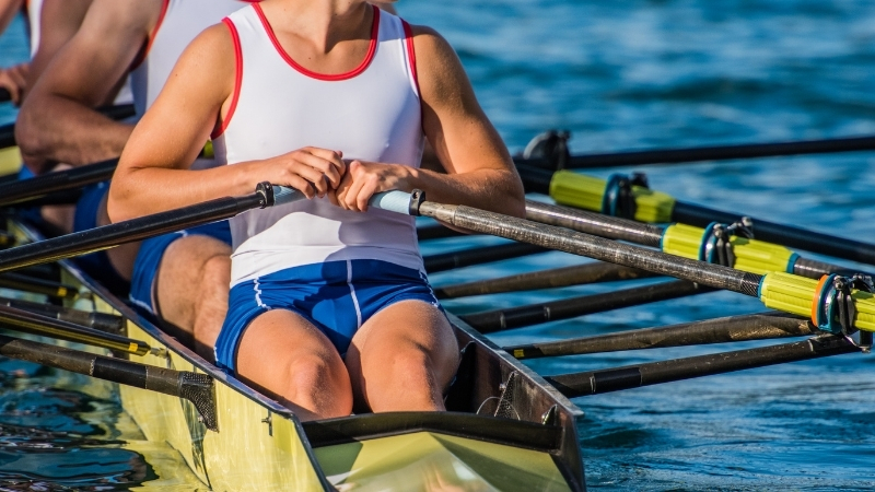 Rowers train together in a racing shell on open water during practice