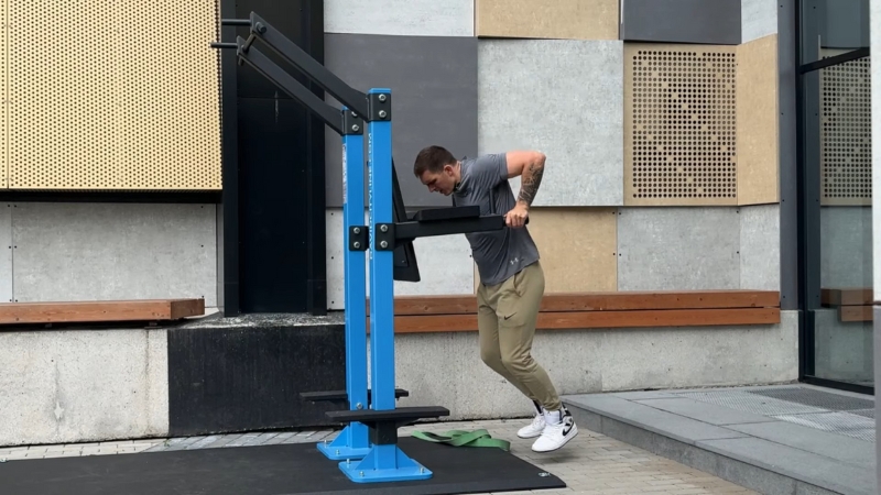 Man perform dips on a fixed Moduseries outdoor fitness unit anchored to a public training area