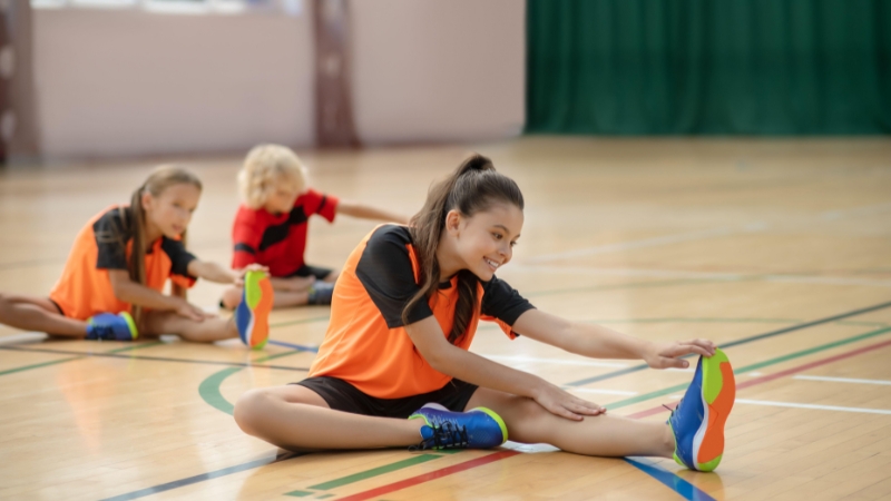 Teen athletes stretch during focused training sessions for professional sports preparation