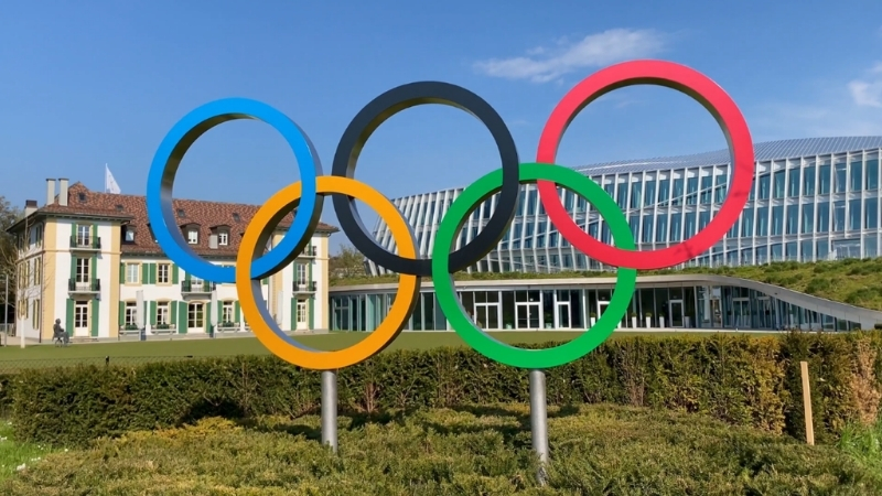 Olympic rings displayed outside a modern sports complex
