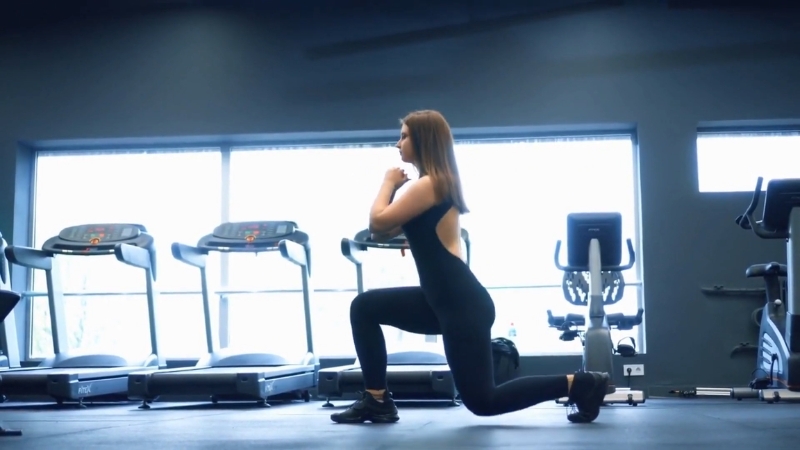 Woman performing a forward lunge in a gym