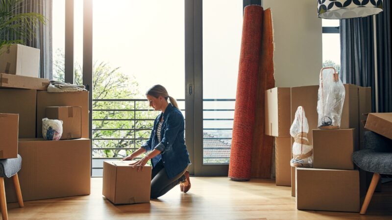 Woman clears space and prepares boxes before lifting at home