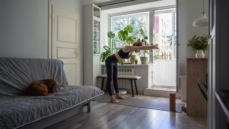 Woman stretches her back and arms at home before lifting tasks