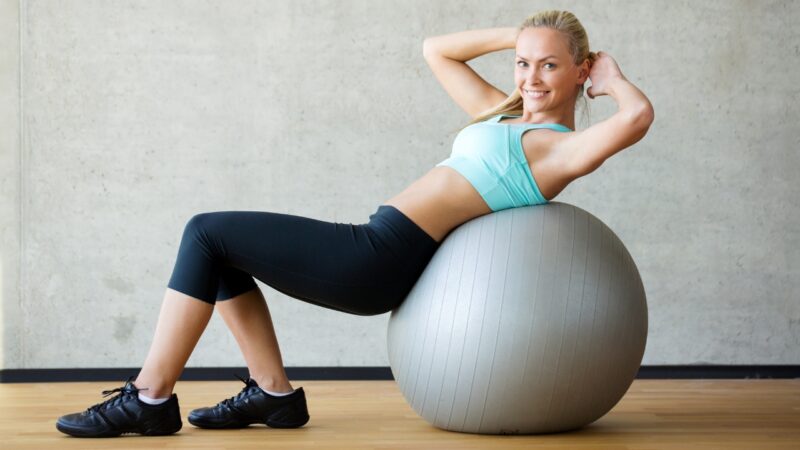 Woman exercising on a stability ball in a gym during a workout