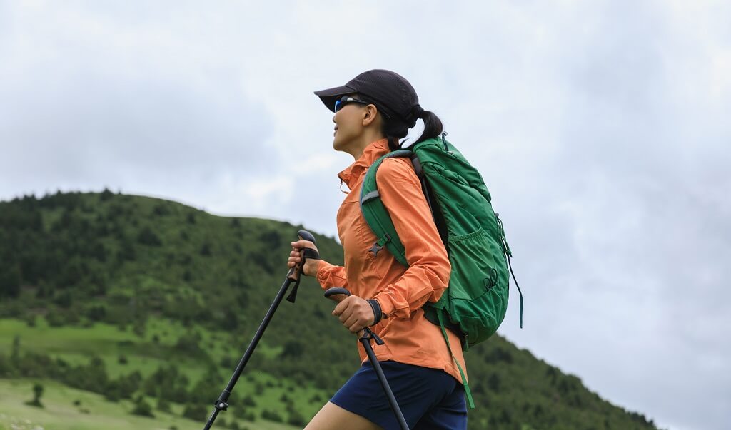 Mountain hiker with trekking poles during endurance and fitness training