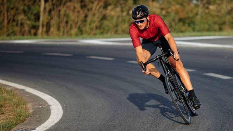 A cyclist leans into a road curve during a focused bike ride.