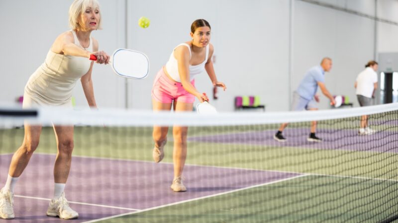Players react during an indoor pickleball match