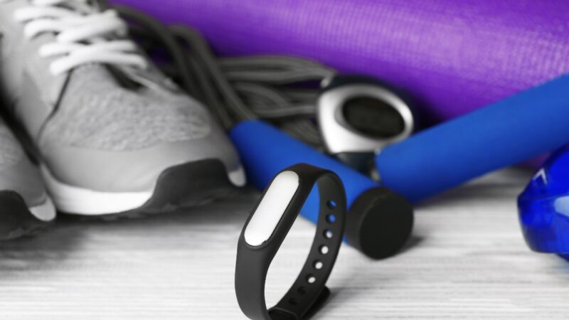 Fitness tracker sits with workout gear on a gym floor