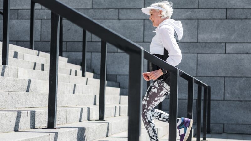 Senior woman runs up outdoor stairs for a cardio workout